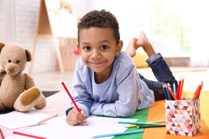 child drawing and smiling